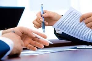 Signature contrat entre 2 personnes avec crayon dans la main