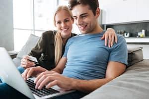 jeune couple avec ordinateur portable et carte bleue